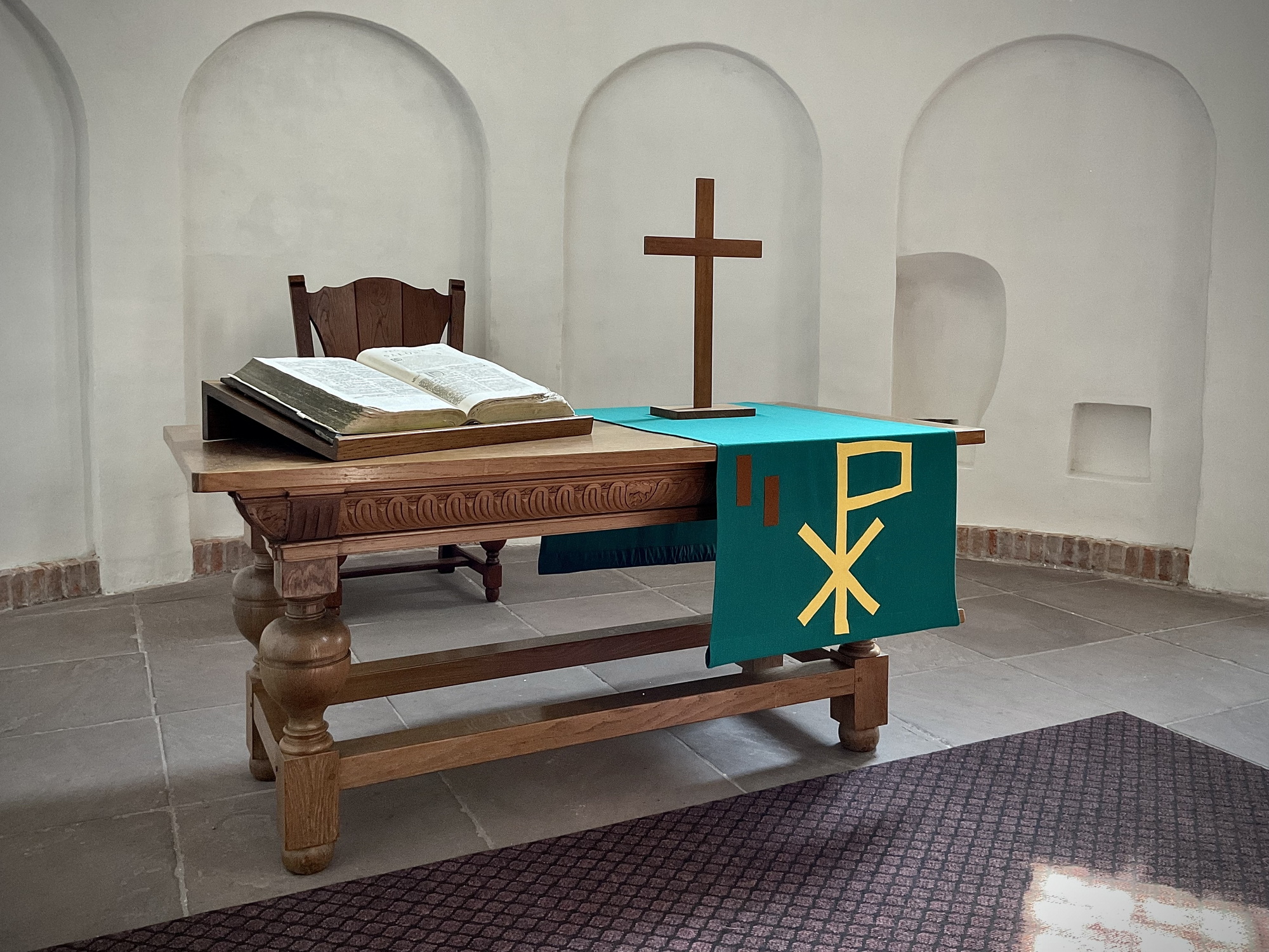 De avondmaalstafel en de oude Bijbel in het koor. Foto: ©Jur Kuipers, 2023.